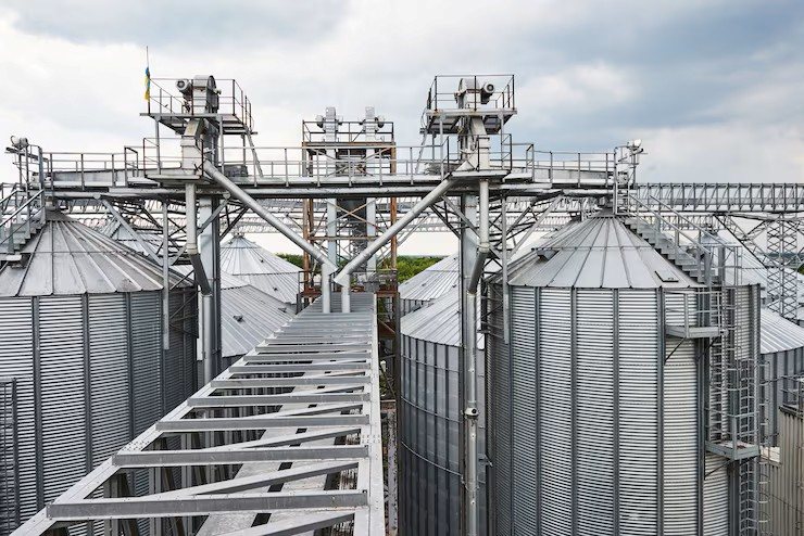 Planta de silos metálicos con pasarelas y transportadores en altura